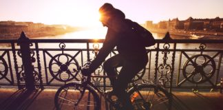 11 Ways To Have A Happy Morning Woman cycling while the sun rises