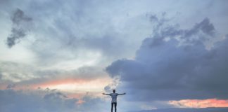 5 Ways to Stand Out Amongst your Peers A man posing on a mountain top as the sun sets